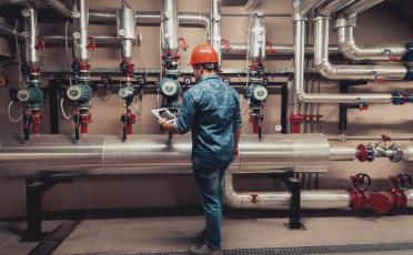 An image of an individual working on valves on a gas pipeline.