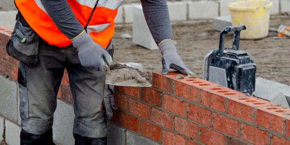 Image of a person laying bricks on a wall